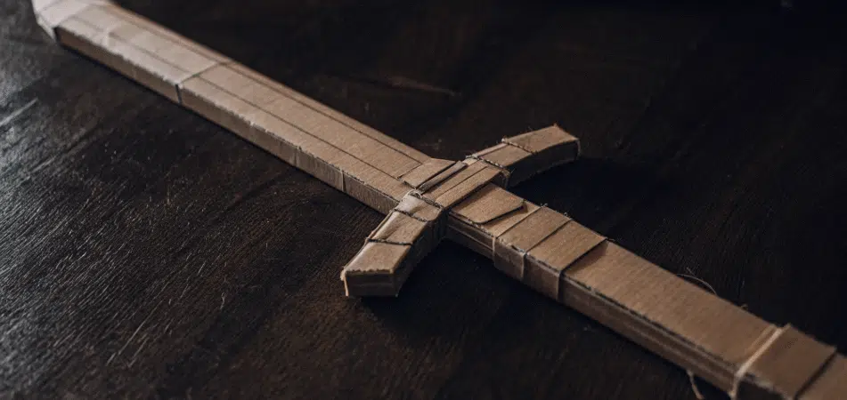 A completed cardboard sword on a black background.