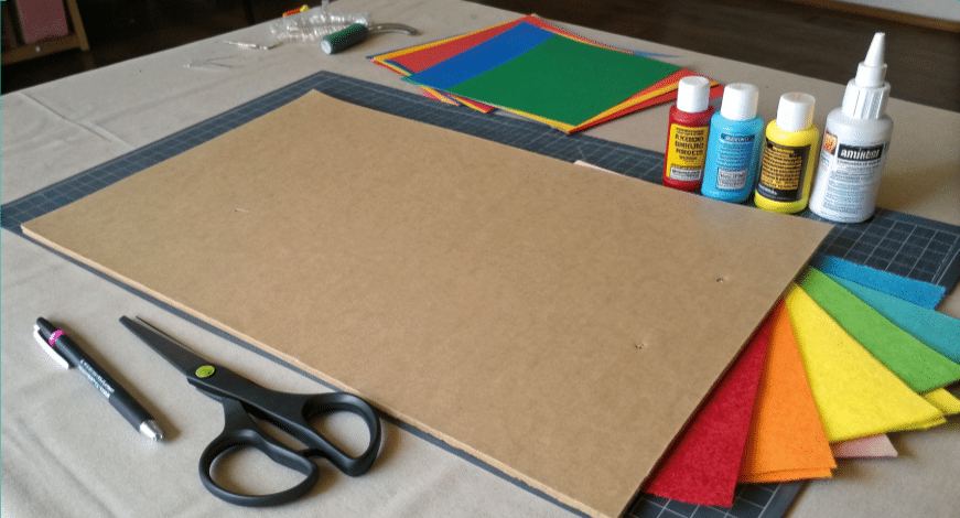 Supplies A photograph of a crafts workspace with various art supplies. The image showcases a variety of tools and materials commonly used in crafting, including colored pencils, scissors, a collection of colored markers and paint, and a selection of fabric-like materials in various colors.