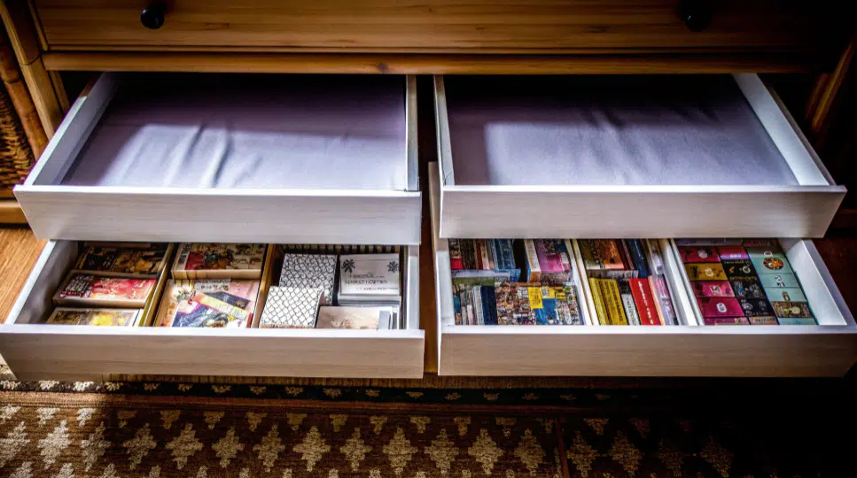 Craft storage drawers filled with board games and puzzles, illustrating effective storage solutions.