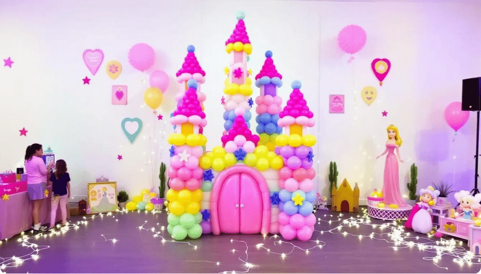 A beautifully arranged balloon castle tower stands prominently in a festive setting, surrounded by princess-themed decorations that enhance the magical atmosphere for a princess party. The vibrant balloons are securely placed, creating an inviting focal point for guests as they arrive.