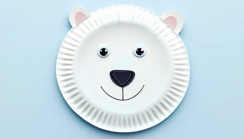 A polar bear paper plate craft with a smiling face.