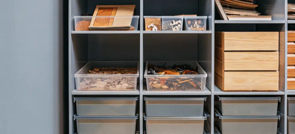 A photo of a series of compartments within a storage unit, featuring various items such as boxes, papers, and other miscellaneous items.