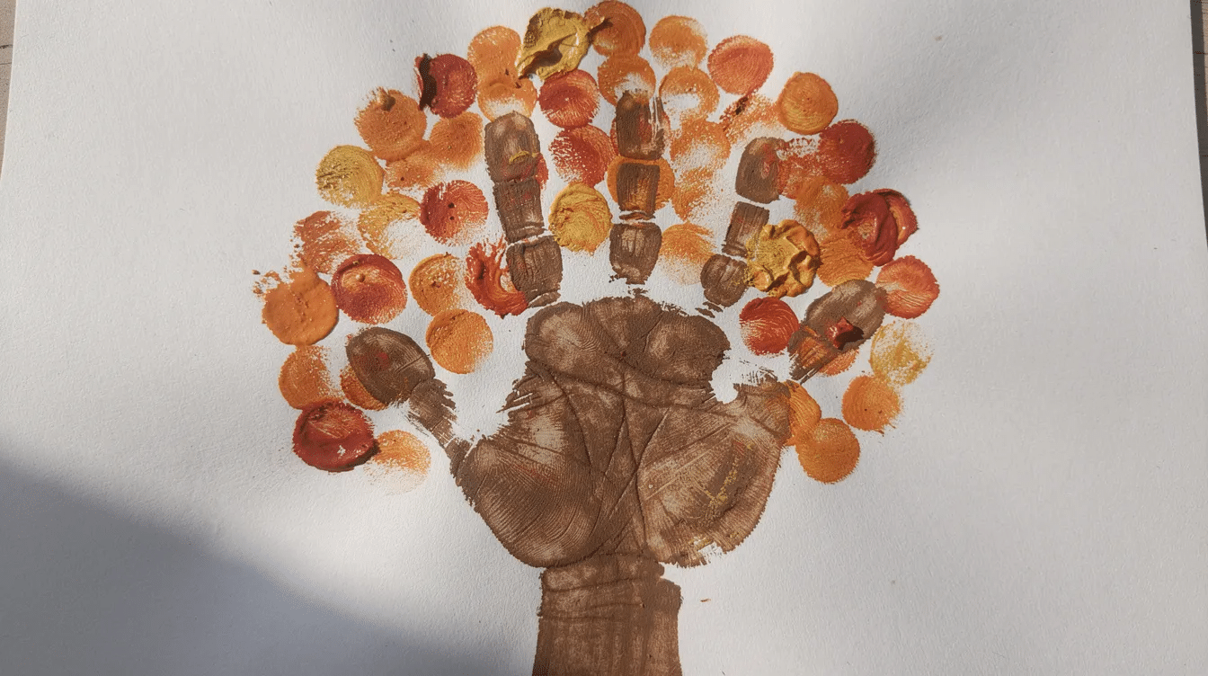 be5cb7cf-ea71-4d5f-9aea-5ef0ff328180 A child's handprint painted in brown is centered on a piece of white paper, surrounded by colorful orange and red fingerprint dots that resemble a fall tree, showcasing a fun fall craft that encourages creativity and fine motor skills in young kids. This autumn-inspired art project captures the essence of the fall season through playful use of colors.